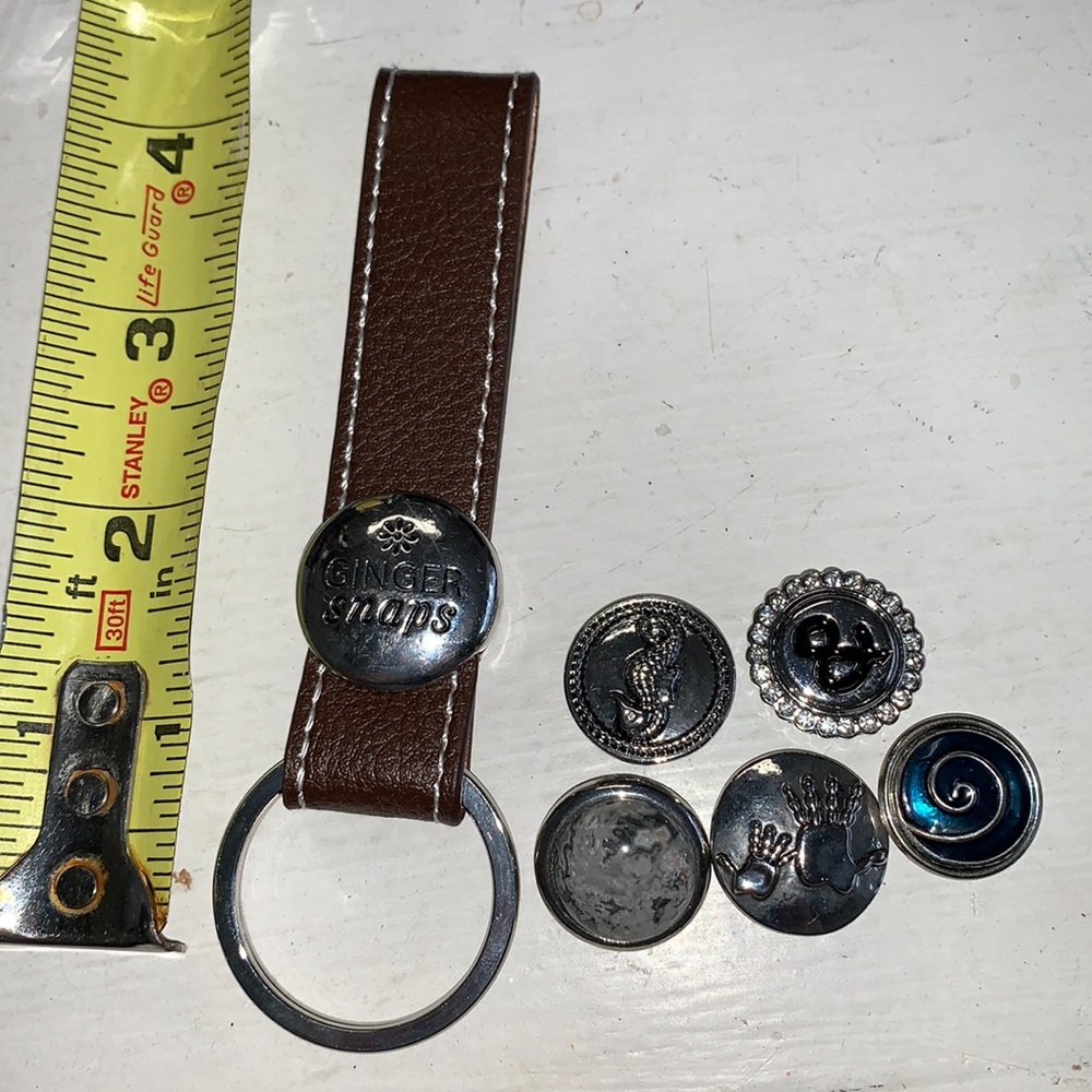 One 4.5” brown leather strap key rings for changeable snaps and 5 snaps.  NWOT
